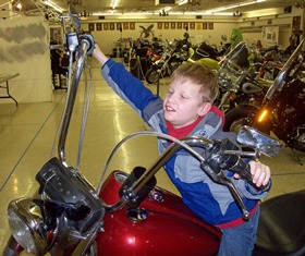 a kid sitting on a motorcycle